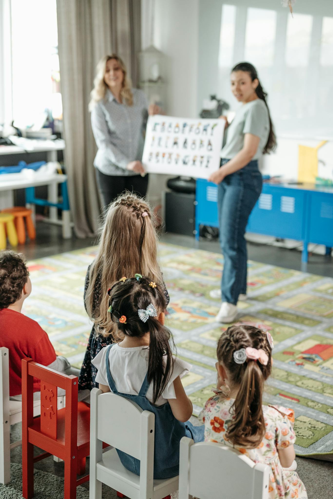 Young children engaged in a fun alphabet lesson with teachers in a kindergarten classroom.